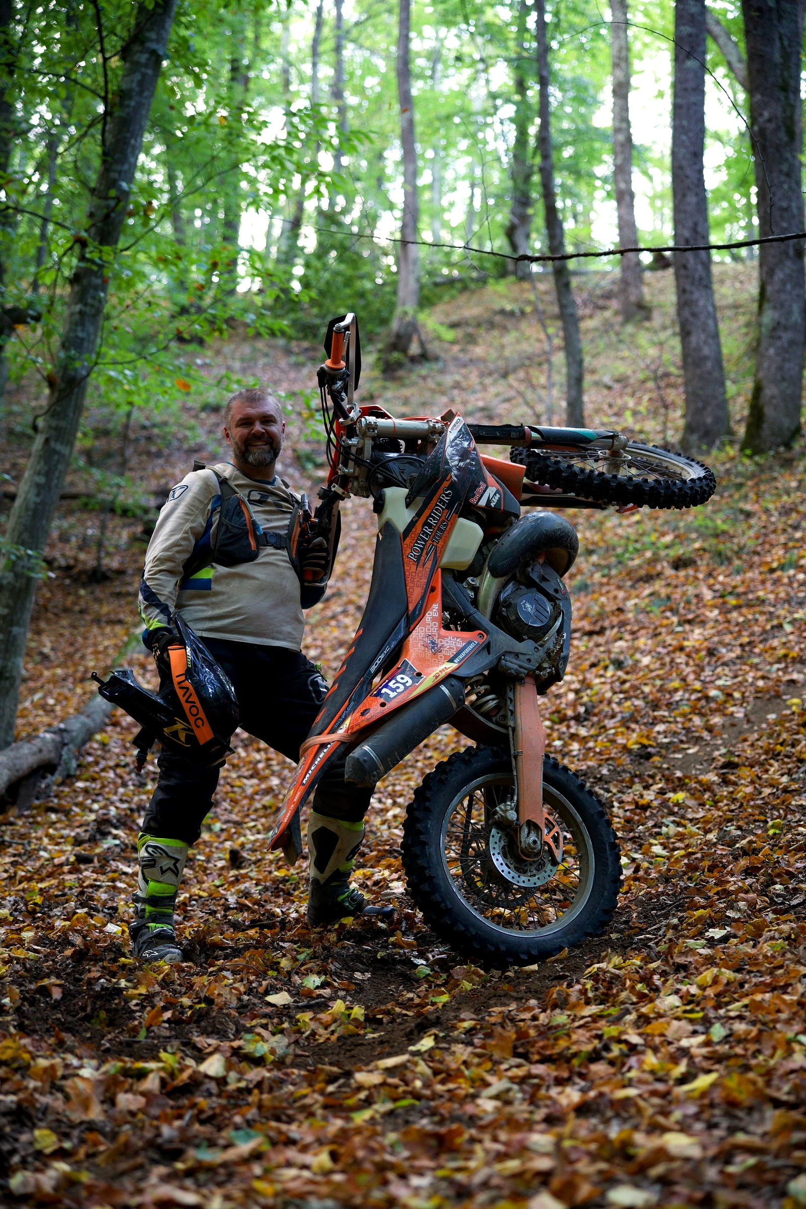 Power Riders Tours guide lifting the front wheel of his KTM on a trail of beech leaves