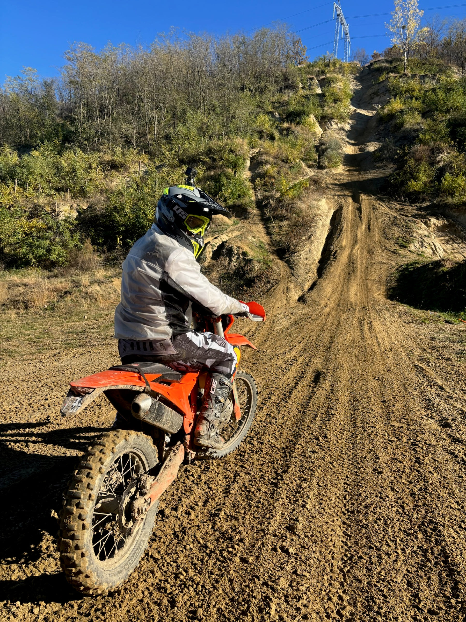 Rider waiting at the foot of a steep rutted climb on a dry hillside