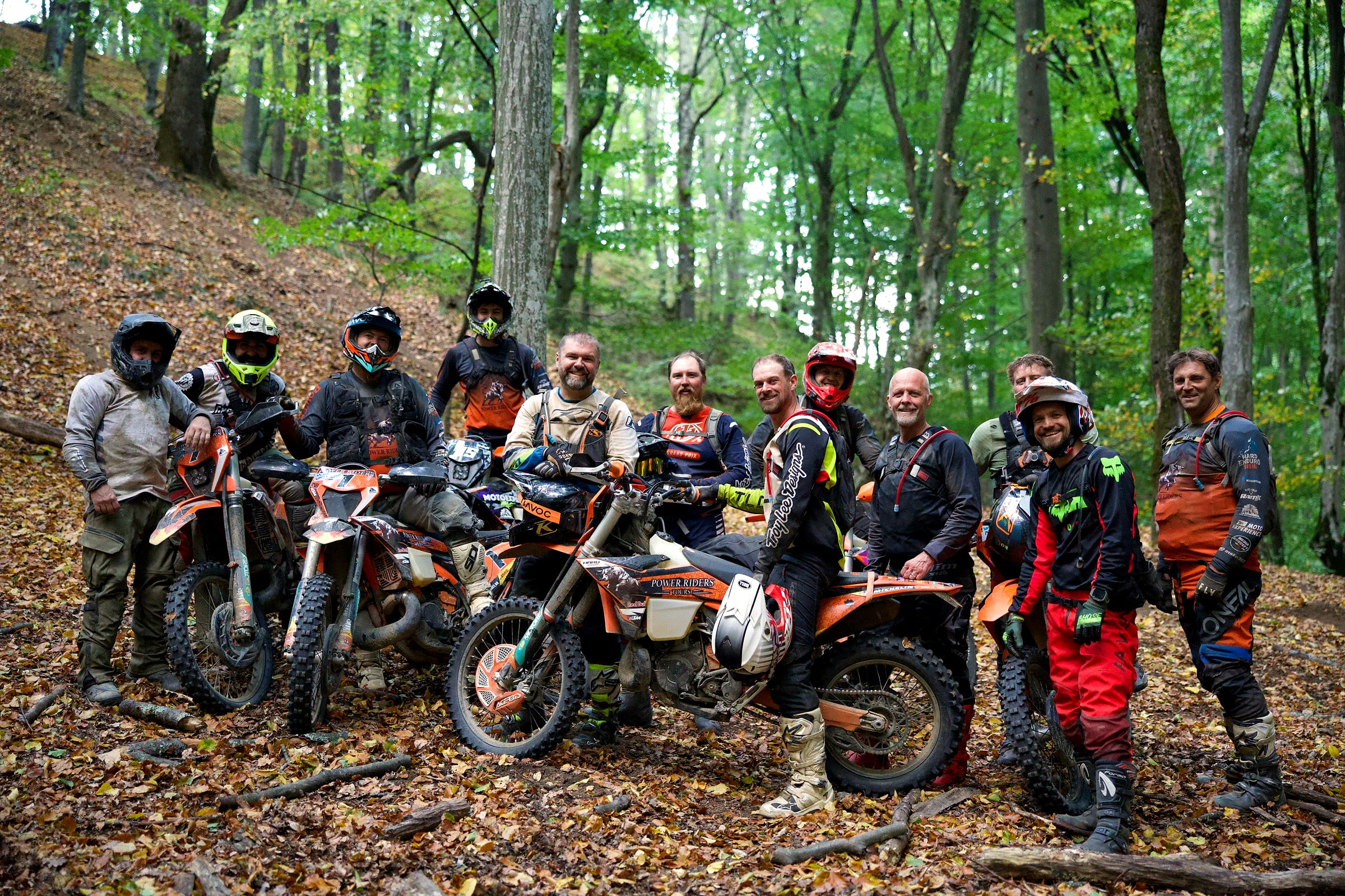Group of twelve riders and their guides with KTM bikes on a beech slope