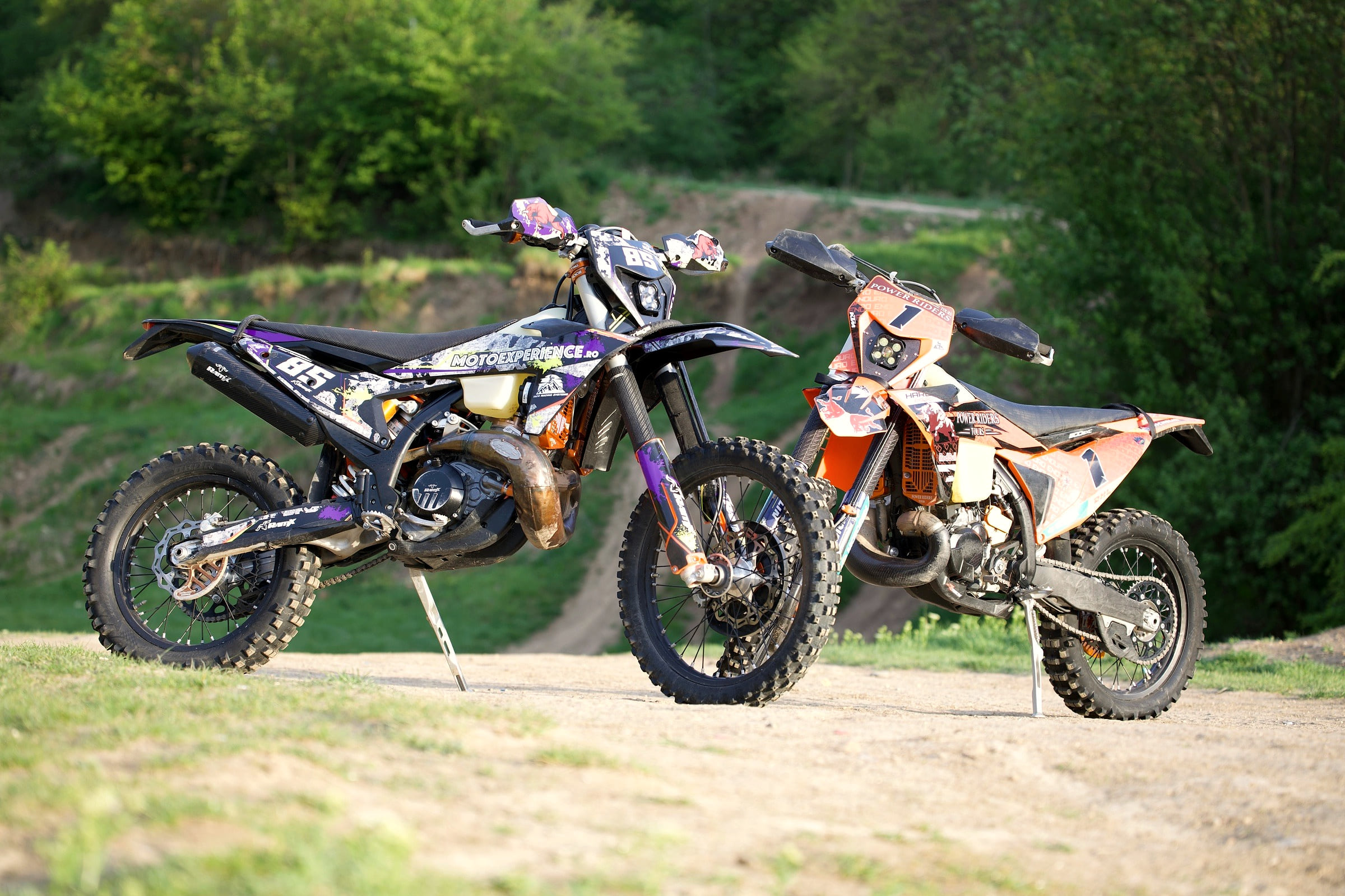 Side view of the orange Power Riders Tours KTM 300 TBI rental bike at a gravel trailhead